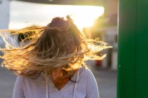 Весела молода жінка на заході сонця світло рухає волосся — стокове фото