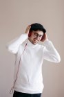 Casual man with headphones standing on grey background — Stock Photo