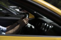 Gros plan des mains masculines sur le volant dans la voiture — Photo de stock