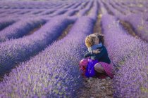 Frau und kleines Mädchen umarmen sich im Lavendelfeld — Stockfoto