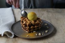 Human hand checking waffles with banana and curry ice cream with spoon — Stock Photo