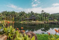 Old oriental building on lake in tropical park, Nanning, China — Stock Photo