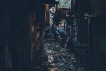 View of narrow dirty and grungy street flooded with water and trash floating on top — Stock Photo