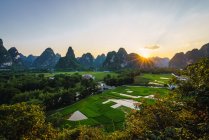 Поля та місто оточений унікальний Скелясті гори на заході сонця, Гуансі, Китай — стокове фото