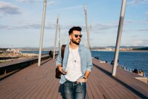 Trendy hipster strolling on waterfront — Stock Photo