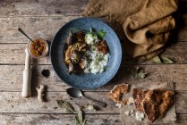 Geröstete Auberginen und Reis mit Gewürzen im Teller auf rustikalem Holztisch — Stockfoto