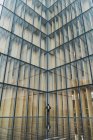 Empresário em pé no pavimento contra o edifício de vidro moderno — Fotografia de Stock
