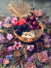 Chia-Pudding mit Früchten in Schüssel und Vintage-Löffel auf dem Tisch mit Blumen und Blättern — Stockfoto