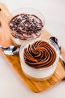 Крупный план шоколадного десерта в чашках на деревянной доске — стоковое фото
