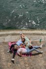 Летом друзья лежат на одеяле на набережной — стоковое фото