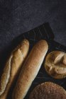 Pão cozido na hora pães em tecido preto — Fotografia de Stock