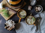 Serviert in Schalen leckere Pilzcreme auf rustikalem Holztisch mit Zutaten — Stockfoto