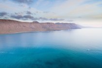 Paisaje de acantilados y superficie azul del mar, La Graciosa, Islas Canarias - foto de stock