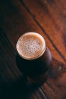 Cerveja forte em vidro em mesa de madeira escura — Fotografia de Stock