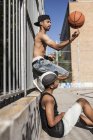 Afro-Junge dreht Basketball am Finger auf dem Platz mit Bruder — Stockfoto
