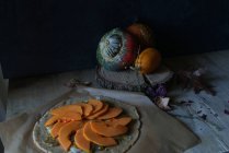 Cocina de calabaza sin cocer en pergamino para hornear sobre mesa de madera rústica - foto de stock