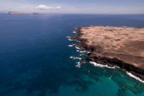 Скалистый утёс в голубом океане, Ла-Грасиоса, Канарские острова — стоковое фото
