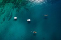 Vista aérea de barcos coloridos e jangadas navegando em águas profundas escuras no dia ensolarado de verão, La Graciosa, Ilhas Canárias — Fotografia de Stock