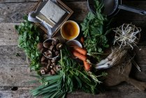 Arrangiertes Gemüse auf rustikalem Tisch zur Zubereitung traditioneller Crepe Banh xeo — Stockfoto