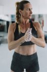 Жінка розтягує крейду на руках під час тренувань у спортзалі — стокове фото