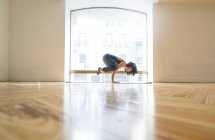 Mulher realizando postura de ioga em sala de aula — Fotografia de Stock