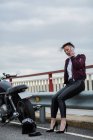 Attraktive Frau spricht mit Smartphone neben ihrem Retro-Motorrad — Stockfoto