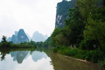Tranquillo fiume Quy Son e la silhouette delle montagne sullo sfondo, Guangxi, Cina — Foto stock