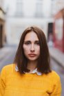 Portrait of serious young woman looking at camera on street — Stock Photo