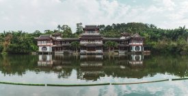 Extérieur du bâtiment oriental ornemental placé sur un lac tropical dans la montagne Qingxiu, Nanning, Chine — Photo de stock