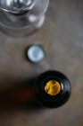 Primer plano de la botella de cerveza abierta sobre fondo gris - foto de stock