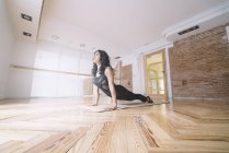 Жінка практикує йогу на килимку в класі — стокове фото
