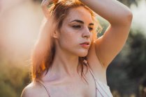 Portrait de jeune femme sensuelle taches de rousseur dans la lumière du soleil regardant loin — Photo de stock