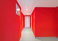 Puertas blancas en corredor rojo moderno - foto de stock
