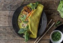 Vietnamese savory fried pancake with vegetables on plate on wooden table — Stock Photo