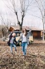 Verspieltes blondes Mädchen und junge Frau amüsieren sich vor altem Lieferwagen auf dem Land — Stockfoto