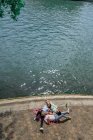 Freunde liegen im Sommer auf Decke am Wasser — Stockfoto