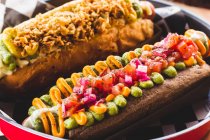 Hot-dogs servis avec garnitures dans le plat — Photo de stock
