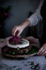 Женщина на полях украшает торт цветами — стоковое фото