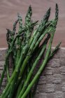 Bunch of fresh green asparagus on brown surface — Stock Photo