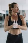 Жінка розтягує крейду на руках під час тренувань у спортзалі — стокове фото
