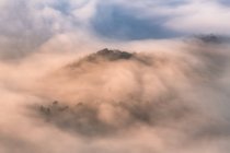 Vue aérienne à couper le souffle des nuages épais couvrant la haute montagne. — Photo de stock