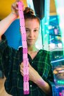 Junge Frau zeigt Spielhallen-Fahrkarten und blickt in Kamera — Stockfoto