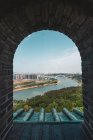 Filmado a través de una vieja ventana de ladrillo con vista del paisaje urbano de Nanning en la orilla del río, China - foto de stock