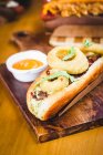 Close-up of delicious fried bun stuffed with meat and cheese topped with fried onion rings — Stock Photo