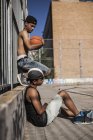 Afro menino segurando basquete na corte com o irmão — Fotografia de Stock