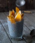 Delicious chia pudding with mango in glass on wooden table — Stock Photo