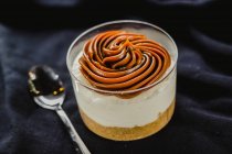 Dessert in tazza con mousse al caramello su tessuto nero — Foto stock