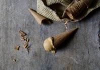 Crème glacée savoureuse en cône de sucre croquant sur table en bois gris — Photo de stock