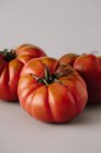 Tomates maduros sazonais frescos sobre fundo cinzento — Fotografia de Stock