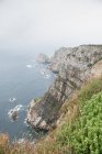 Rocky cliffs and magnificent sea on foggy day — Stock Photo